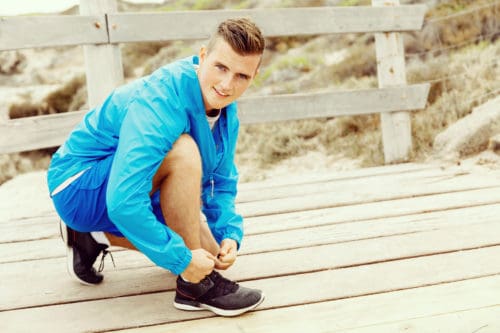Runner laces his shoes and prepares to jogging