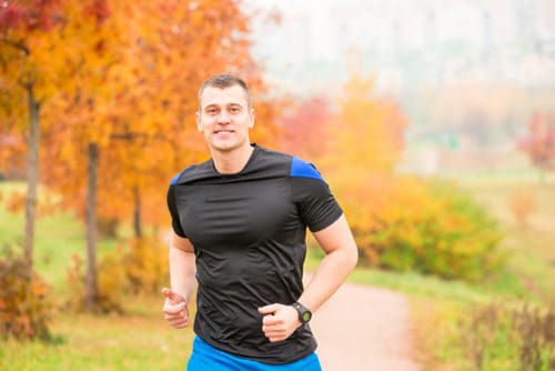muscular man running on a footpath in the park